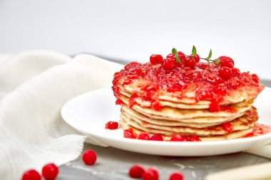 Amerikan krep reçelli - berry, kartopu, kızılcık gri arka plan üzerinde. Berry sos ve nane ile ev yapımı gözleme. Sağlıklı kahvaltı berry reçelli taze sıcak krep ile
