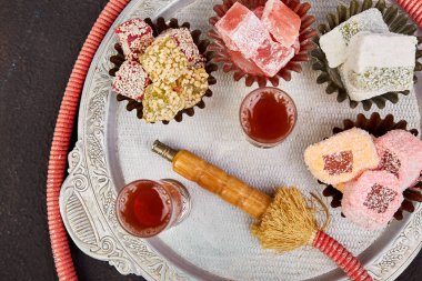 Çeşitli Türk lokumu nargile tüp siyah adam yakınındaki metal tepsi üzerinde geleneksel gümüş kasede ayarla