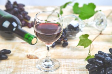 Şişe, cam ve ahşap arka plan üzerinde üzüm ile kırmızı şarap kavramı. Şarap başlık görüntü. Kadehlerin