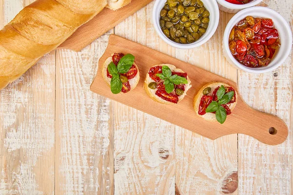 Bruschetta Veya Crostini Ile Güneş Domates Kapari Ahşap Mutfak Tahtası — Stok fotoğraf