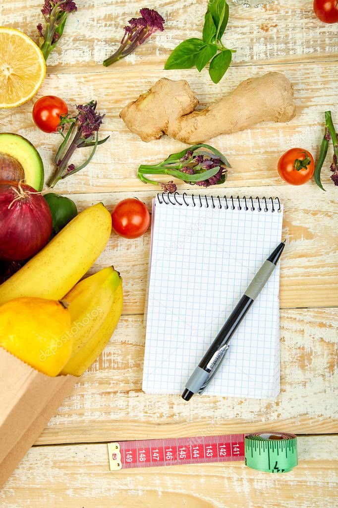 Shopping list, recipe book, diet plan. Grocering concept. Full paper bag of different fruits and vegetables, ingredients for healthy cooking Diet or vegan food, vegetarian. Top view. Flat lay.