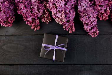 Siyah küçük hediye kutuları menekşe, mor kurdele çiçek doğal Lila ile süslenmiş ile sarılmış. Çiçek dekor öğeleri. Uzay kopyalayın. Metin için yer. 