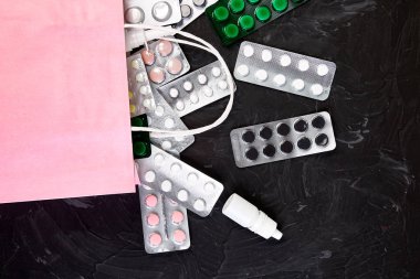 Alışveriş çantası tıp hapları ve blister koyu arka plan üzerinde çeşitli. Yaratıcı bir fikir. Sağlık pazarı kavramı. Düz yatıyordu. 