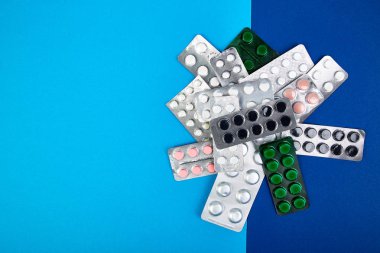 Hap, tablet ve blister mavi zemin üzerine. Sağlık kavramı. Düz yatıyordu. Kopya alanı.