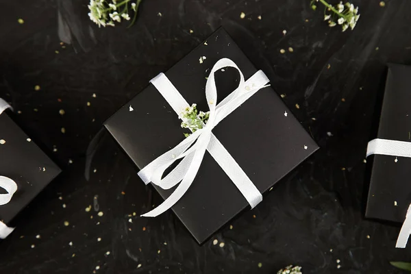 Wrapping modern Christmas or Birthday gifts presents. Gift boxes in Black and White color with flowers. Flat lay, top view. Beautiful.