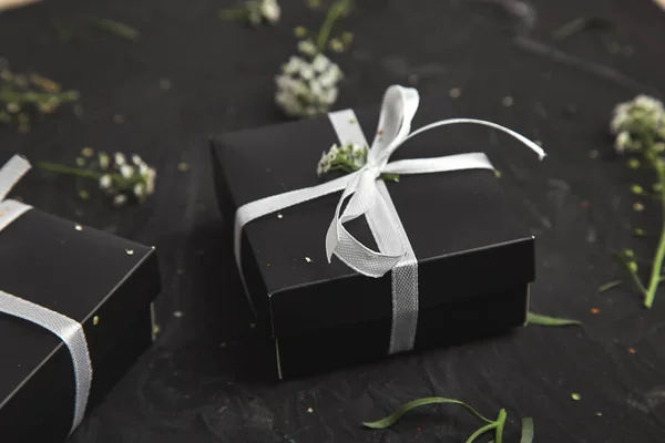 Wrapping modern Christmas or Birthday gifts presents. Gift boxes in Black and White color with flowers. Flat lay, top view. Beautiful.