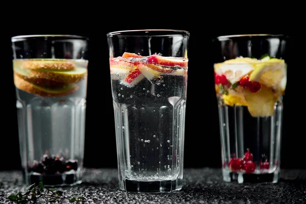 Detoks çeşitli infüzyon su kivi, elma, lavanta, zencefil, limon, siyah arka plan üzerine nane. Yaz ev yapımı kokteyl serinletici. Diyet. Sağlıklı içecek