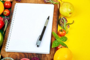 Alışveriş listesi, yemek tarifi kitabı, diyet planı. Taze çiğ sebze, meyve ve sağlıklı yemek pişirmek için malzemeler. Üstten Görünüm, metin için yer. Diyet veya vegan gıda, sağlıklı pişirme kavramı. Düz yatıyordu. Senin tarifi kavramı için not etmek.