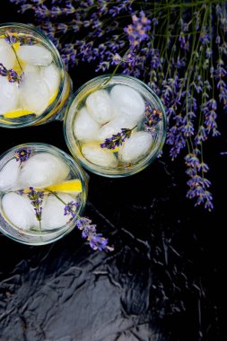 Lavanta Limonata limon ve siyah arka plan üzerine buz. Suyu detoks. Yaz içeceği. Diyet kokteyl. Güzel. Üstten görünüm. Kopya alanı.