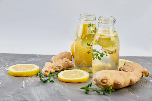 Trendy Detoks sağlıklı içecek. Su şişe malzemeler, zencefil, Limon Detoks, gri arka plan üzerine nane. Yaz içeceği, limonata. Diyet. Kopya alanı. 