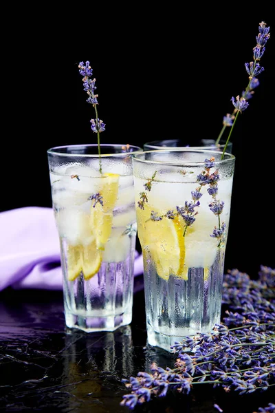 Lavender lemonade with lemon and ice on black background. Detox water. Summer drink. Diet cocktail. Beautiful.
