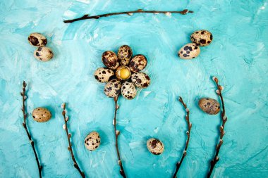 Bıldırcın yumurta söğüt dalı ile mavi arka plan üzerinde. 