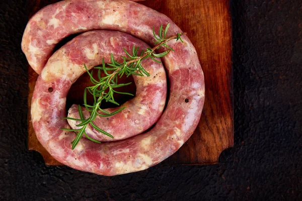 Embutidos de cerdo en espiral crudos con romero, sal y peper — Foto de Stock