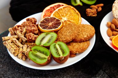 Sağlıklı aperatifler - çeşitli yulaf granola bar, pirinç cips, badem, kivi, portakal kurutulmuş