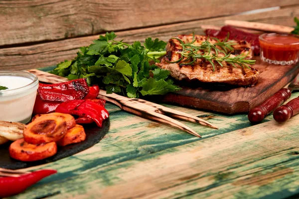 Grilovaný steak na dřevěné řezací desce s rozmankou grilované zeleniny — Stock fotografie