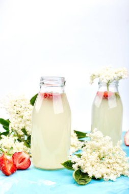 Mavi arka planda elderflower ve çilek ile Kombucha çayı.