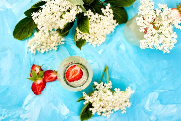 Κομπούτσα τσάι με λουλούδι και φράουλα σε μπλε φόντο. — Φωτογραφία Αρχείου