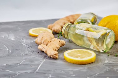 Trendy Detoks sağlıklı içecek. Su şişe malzemeler, zencefil, Limon Detoks, gri arka plan üzerine nane. Yaz içeceği, limonata. Diyet. Düz yatıyordu. Üstten Görünüm. Kopya alanı 
