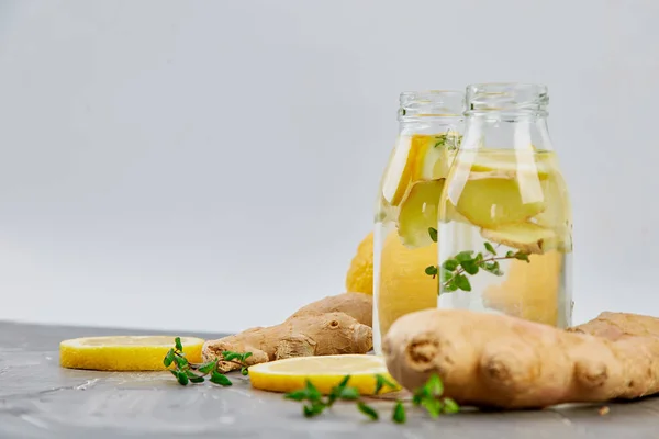 Trendy Detoks sağlıklı içecek. Su şişe malzemeler, zencefil, Limon Detoks, gri arka plan üzerine nane. Yaz içeceği, limonata. Diyet. Kopya alanı. 