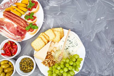 İtalyan antipasti şarap aperatifler küme. Meze yemek tabağı ile salam, peynir, üzüm, Prosciutto Brushettas grunge üzerinde arka plan gri. İtalyan yemeği. Akdeniz. Teras yatıyordu. Kopya alanı