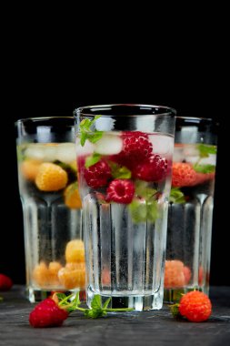 Aromalı su üç rengiyle ahududu - infused detoks kırmızı, turuncu, siyah zemin üzerine sarı... Canlandırıcı yaz ev yapımı cocktai