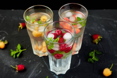 Aromalı su üç rengiyle ahududu - infused detoks kırmızı, turuncu, siyah zemin üzerine sarı... Canlandırıcı yaz ev yapımı cocktai