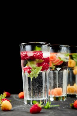 Aromalı su üç rengiyle ahududu - infused detoks kırmızı, turuncu, siyah zemin üzerine sarı... Canlandırıcı yaz ev yapımı cocktai