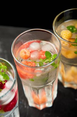 Aromalı su üç rengiyle ahududu - infused detoks kırmızı, turuncu, siyah zemin üzerine sarı... Canlandırıcı yaz ev yapımı cocktai