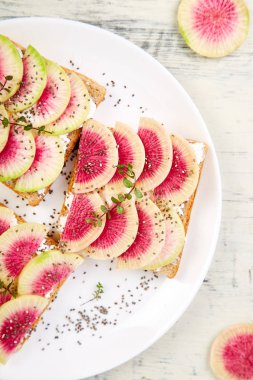 Dilimlenmiş karpuz turp veya Çin Daikon, Chia ve whte arka planda süzme peynir sağlıklı kahvaltı tost. Üst görünüm. Düz yatıyordu. Boşluk Kopyala. 