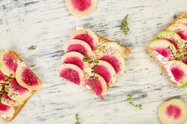 Dilimlenmiş karpuz turp veya Çin Daikon, Chia ve whte arka planda süzme peynir sağlıklı kahvaltı tost. Üst görünüm. Düz yatıyordu. Boşluk Kopyala. 