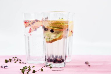 Detoks çeşitli infüzyon su kivi, elma, lavanta, zencefil, limon, nane pembe bir arka plan üzerinde. Yaz ev yapımı kokteyl serinletici. Diyet. Sağlıklı içecek. Kopya alanı.