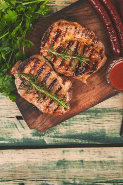 Izgara et. Rustik arka planda ahşap kesme tahtasında Steak domuz ızgara üst görünüm. Düz yatma.