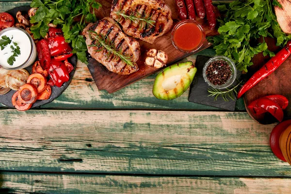 Izgara sebzeler çeşitli ahşap kesme tahtasında biftek domuz ızgara — Stok fotoğraf
