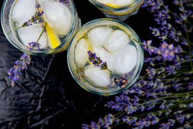 Siyah arka plan üzerinde limon ve buz ile Lavanta limonata.