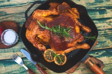 Ahşap rustik arka plan üzerinde tavada elma ile pişmiş bütün tavuk. Tahta tahtada servis edilir. Noel tavuğu