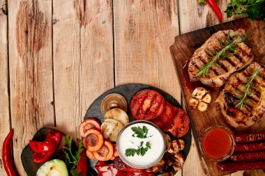 Izgara et. Rustik arka planda ızgara sebze çeşitli ahşap kesme tahtasında Steak domuz ızgara üst görünüm. Düz yatıyordu. Boşluk Kopyala.