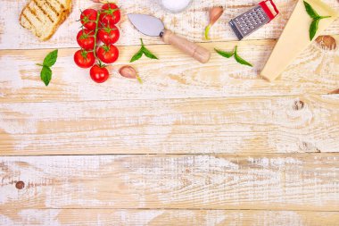 İtalyan gıda maddeleri, asma domates, fesleğen, parmesan, zeytin yağı, sarımsak, ahşap arka planda ekmek pişirmek için hazır. Üstteki görünüm, Yukarıdakilerin görünümü. Boşluk Kopyala. Düz yatıyordu. Gıda çerçevesi