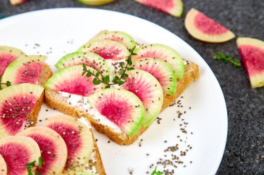 Dilimlenmiş karpuz turp veya Çin Daikon, Chia ve siyah arka planda süzme peynir sağlıklı kahvaltı tost. Boşluk Kopyala. 