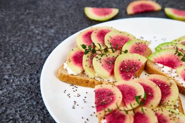Dilimlenmiş karpuz turp veya Çin Daikon, Chia ve siyah arka planda süzme peynir sağlıklı kahvaltı tost. Boşluk Kopyala. 