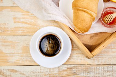 Günaydın. Continental kahvaltı Ristiç ahşap arka plan üzerinde. Fincan kahve, portakal suyu, kruvasan, ahşap tepsi yukarıdan reçel. Üstten görünüm. Düz yatıyordu. Uzay kopyalayın. Düzen