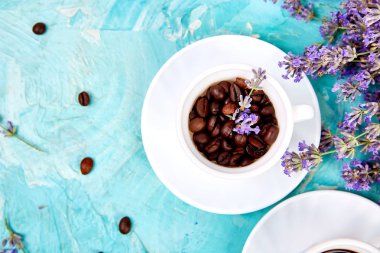 Yukarıdan mavi arka plan üzerinde fincan ve lavanta çiçek Tahıl Kahve. 