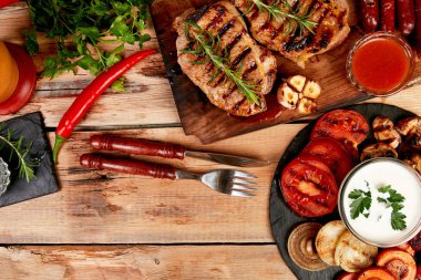 Izgara et. Rustik arka planda ızgara sebze çeşitli ahşap kesme tahtasında Steak domuz ızgara üst görünüm. Düz yatıyordu. Boşluk Kopyala.