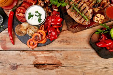 Izgara et. Rustik arka planda ızgara sebze çeşitli ahşap kesme tahtasında Steak domuz ızgara üst görünüm. Düz yatıyordu. Boşluk Kopyala.