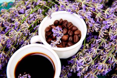 Kahve, fincan kahve taneleri ve yukarıdan yeşil arka plan üzerinde lavanta çiçeği. Günaydın konsepti. Kadın çalışma masası. Rahat kahvaltı. Mockup. Düz döşeme stili