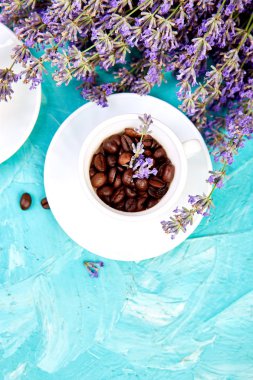 Yukarıdan mavi arka plan üzerinde fincan ve lavanta çiçek Tahıl Kahve.