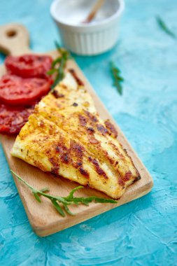 Ahşap tahta üzerinde domates ile ızgara pike fileto