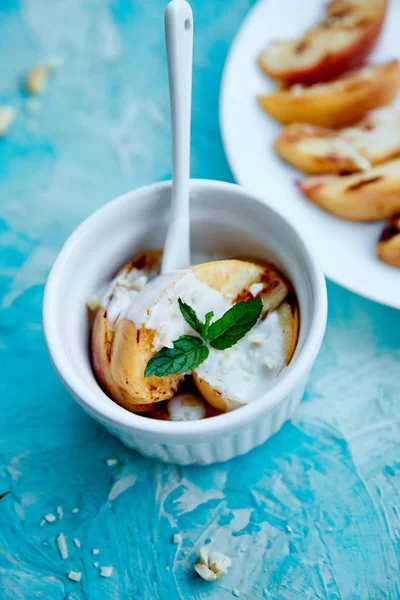 Beyaz tabakta dondurma ile ızgara şeftali