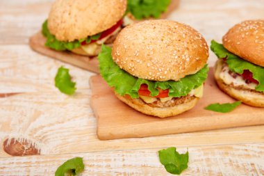 Işık arka planda ahşap masada zanaat sığır Burger. Sokak Yemeği, Fast Food. Peynir ve ahşap masada ev yapımı sulu hamburgerler. Boşluk Kopyala.