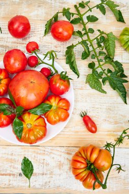Domates arka plan karışımı. Beyaz ahşap masa arka planda güzel sulu organik kırmızı domates. Temiz yemek konsepti. Kopya alanı, düz yatıyordu