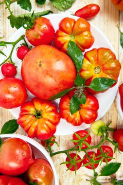 Domates arka plan karışımı. Beyaz ahşap masa arka planda güzel sulu organik kırmızı domates. Temiz yemek konsepti. Kopya alanı, düz yatıyordu